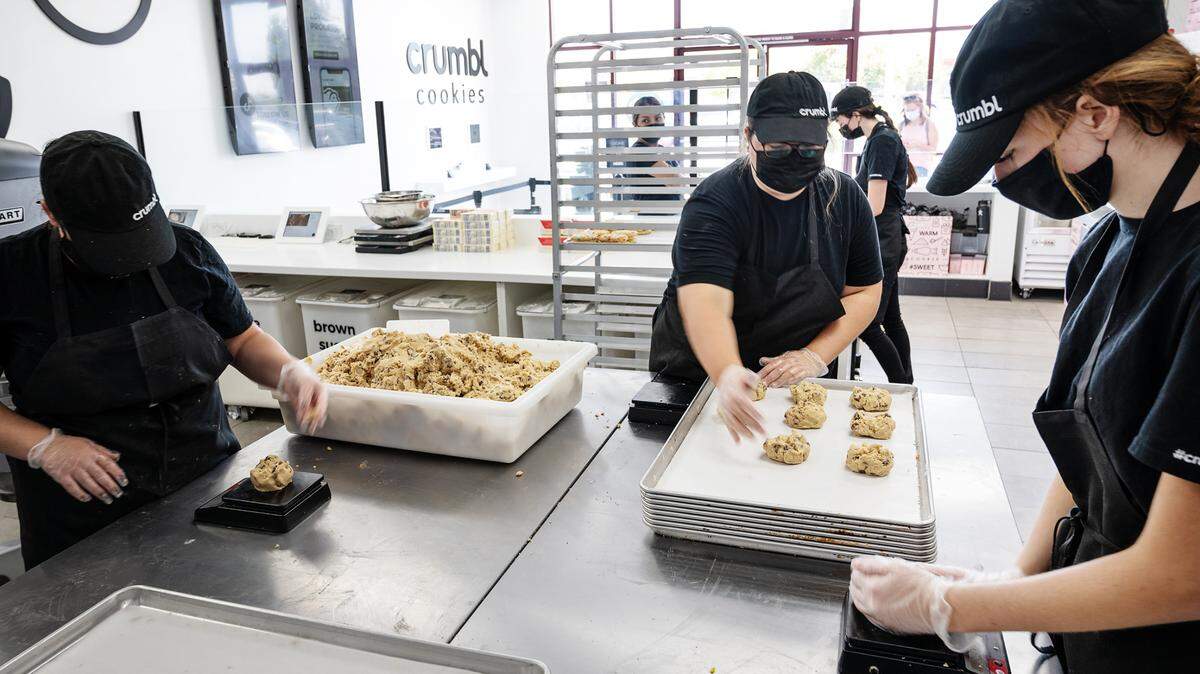 Cassidy Sanchez, right, and her co-workers measure out chocolate chip cookie dough at Crumbl Cookies in Riverbank, Calif., on Thursday, Sept. 9, 2021.
