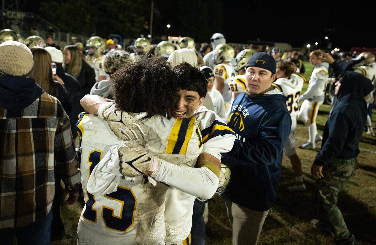 Turlock teammates Dominick Luna (15) and Jr. Silva hug after the Bulldogs 43-42 win over Central Catholic in the Sac-Joaquin Section Division I playoff game at Central Catholic High School in Modesto, Friday, Nov. 15, 2024.