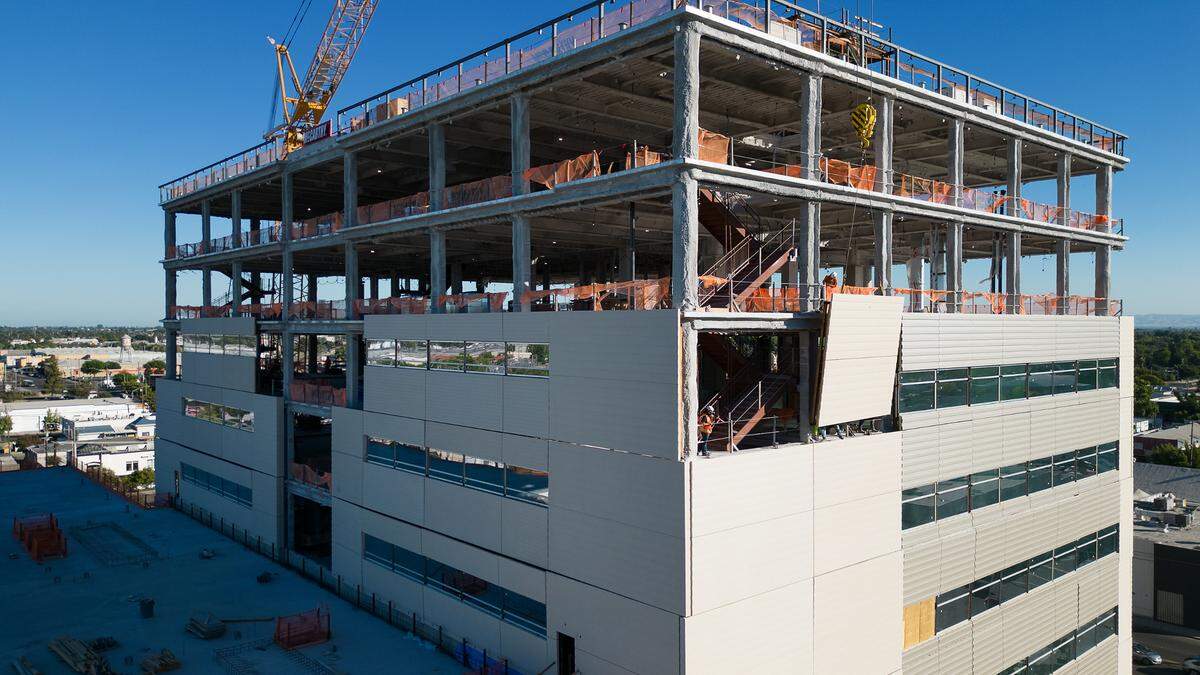 A crane lowers siding material as construction continues on the new Stanislaus County Superior Courthouse in Modesto, Calif., Friday, July 28, 2023.