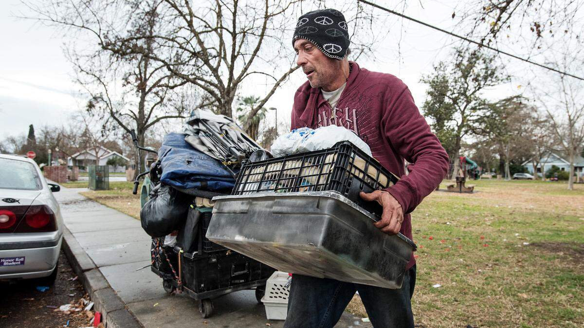 Homeless resident Sam Borba gathers up possessions before city workers arrive to remove what city officials say is illegally stored property at Broadway Park in Turlock, Calif., Wednesday, Jan. 9, 2019.