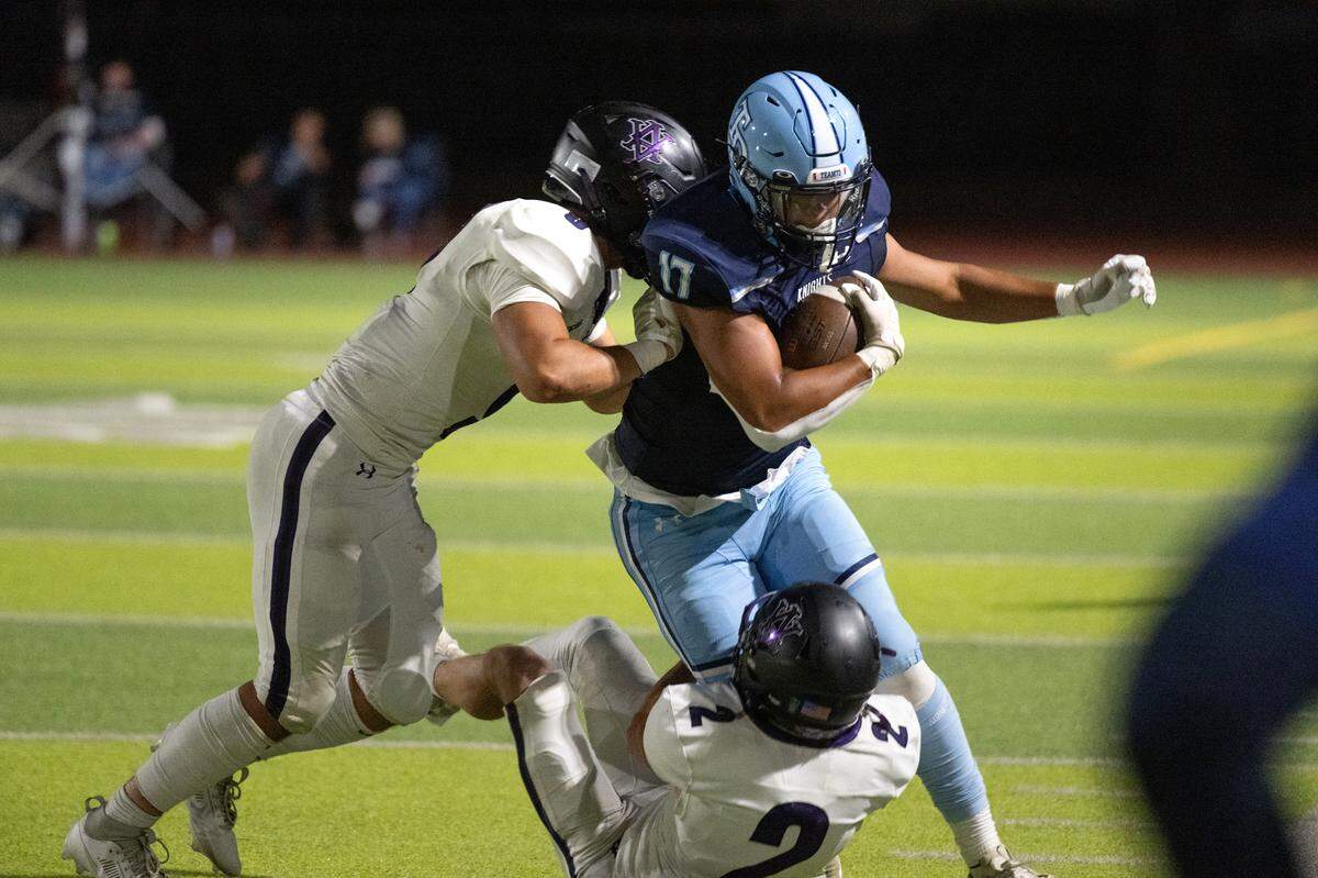 Downey’s Jayceon Sloan takes on Amador Valley defenders during the non-league game at Downey High School in Modesto, Calif., Friday, Sept. 13, 2024.