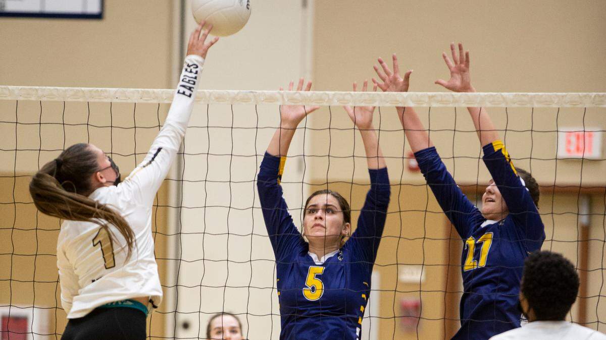 Riley Geary, 1, of Enochs High tips the ball over Gregoria Highs, Sophia Franzia, 5, and Kylie Kriese, 27. Enochs High varsity volleyball traveled across town to take on Gregori High Tuesday, May, 11, 2021.