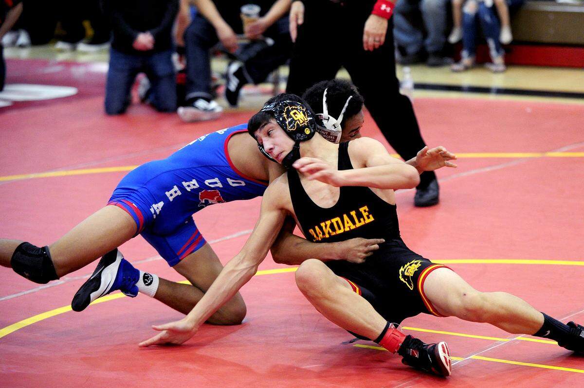 Oakdale wrestler Brandon Abell tries to spin around to gain advantage on Durham wrestler Yousuf Zigan, on Saturday, December 9, during the James Riddle Memorial Wrestling Tournament at Oakdale High School.