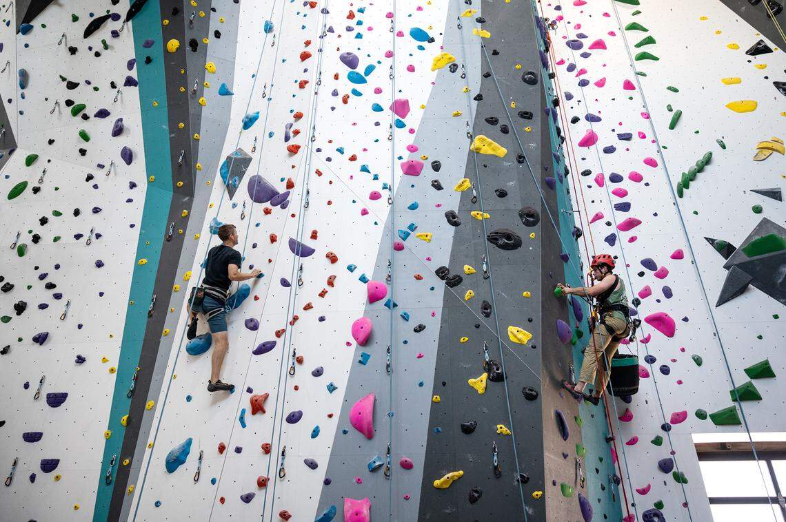 Jon Tillay of Modesto, left, ascends a climbing route while route setter William Swartz, right, creates a new clibimg route at Alpine Climbing Adventure Fitness in Ripon, Calif., on Wednesday, June 30, 2021.