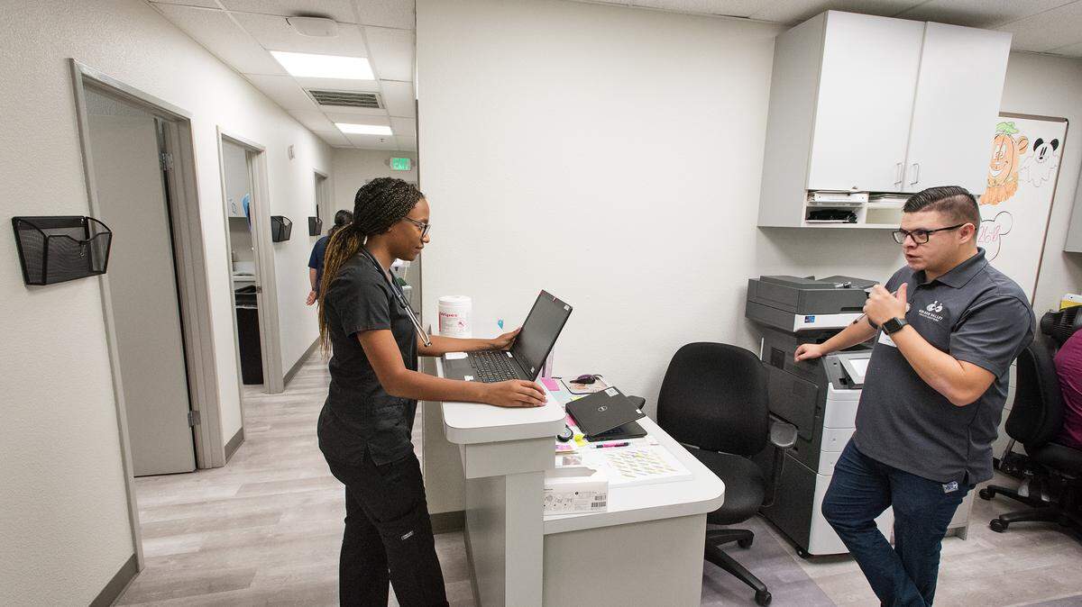 Medical assistant Rosa Mejia, left, talks with clinic supervisor Robert Rabago, right, at Golden Valley Health Centers Florida Avenue center in Modesto, Calif., on Wednesday, Sept. 26, 2018. The Florida Avenue clinic has recently been remodeled.
