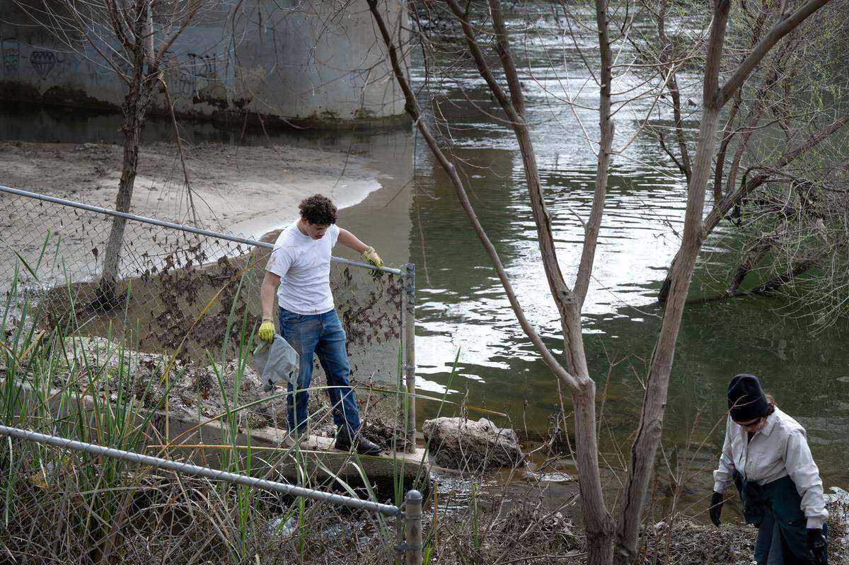 Volunteers, including Johansen High junior Jesus Atayde, left, clean up trash as part of the Operation 9-2-99 river cleanup along the Tuolumne River in Modesto, Calif., Saturday, March 9, 2024.
