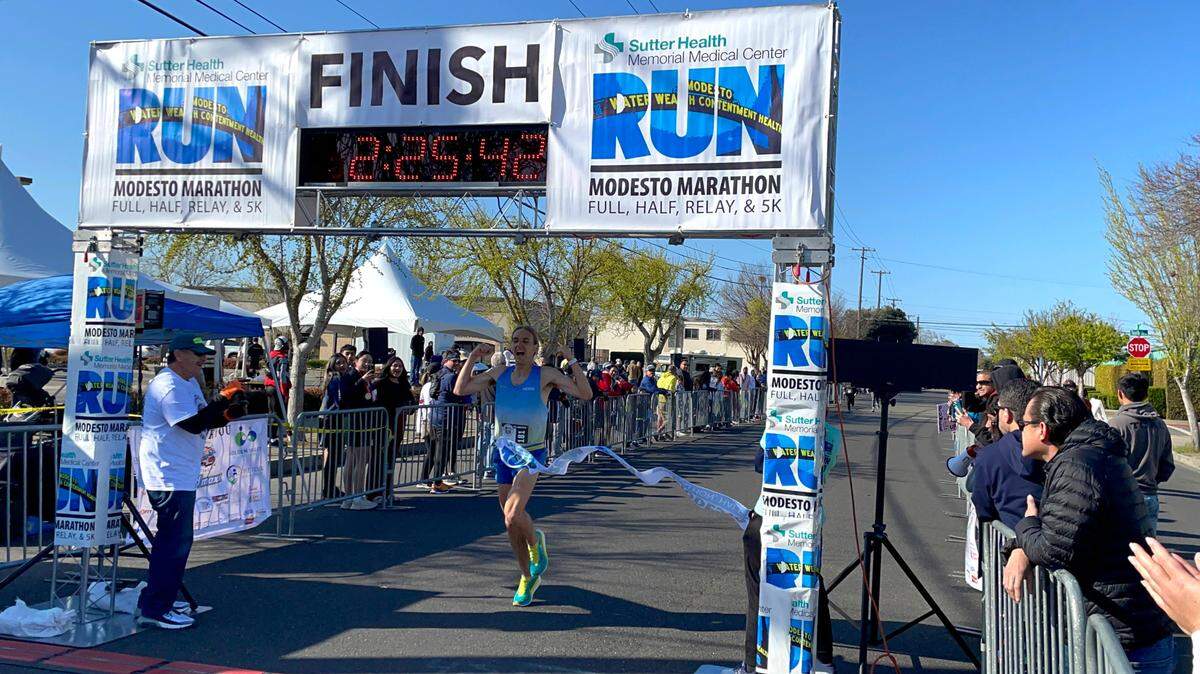 Modesto runner Michael Mrgudic, 27, crosses the finish line to win the Modesto Marathon with a time of 2:25:41 on Sunday, March 26, 2023.
