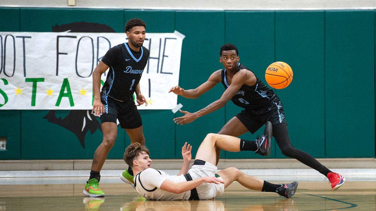 Pitman’s Seth Vink passes off the ball under pressure from Downey’s Jorden Lewis (1) and Reuben Lewis (0) during the Central California Athletic League game in Turlock, Calif., Wednesday, Jan. 18, 2023. Downey won the game 52-44.