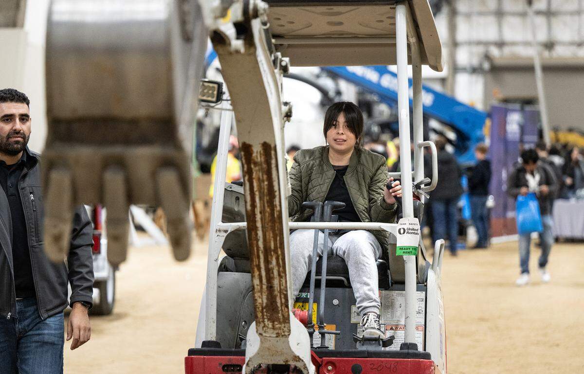 Pacheco High student Xitlali Jacobo operates an excavator during Construction Trades Day at the Modesto Junior College West Campus in Modesto, Calif., Wednesday Nov. 15, 2023. The event was organized by the Valley Builders Exchange, a Modesto-based group that helps contractors with hiring and training.