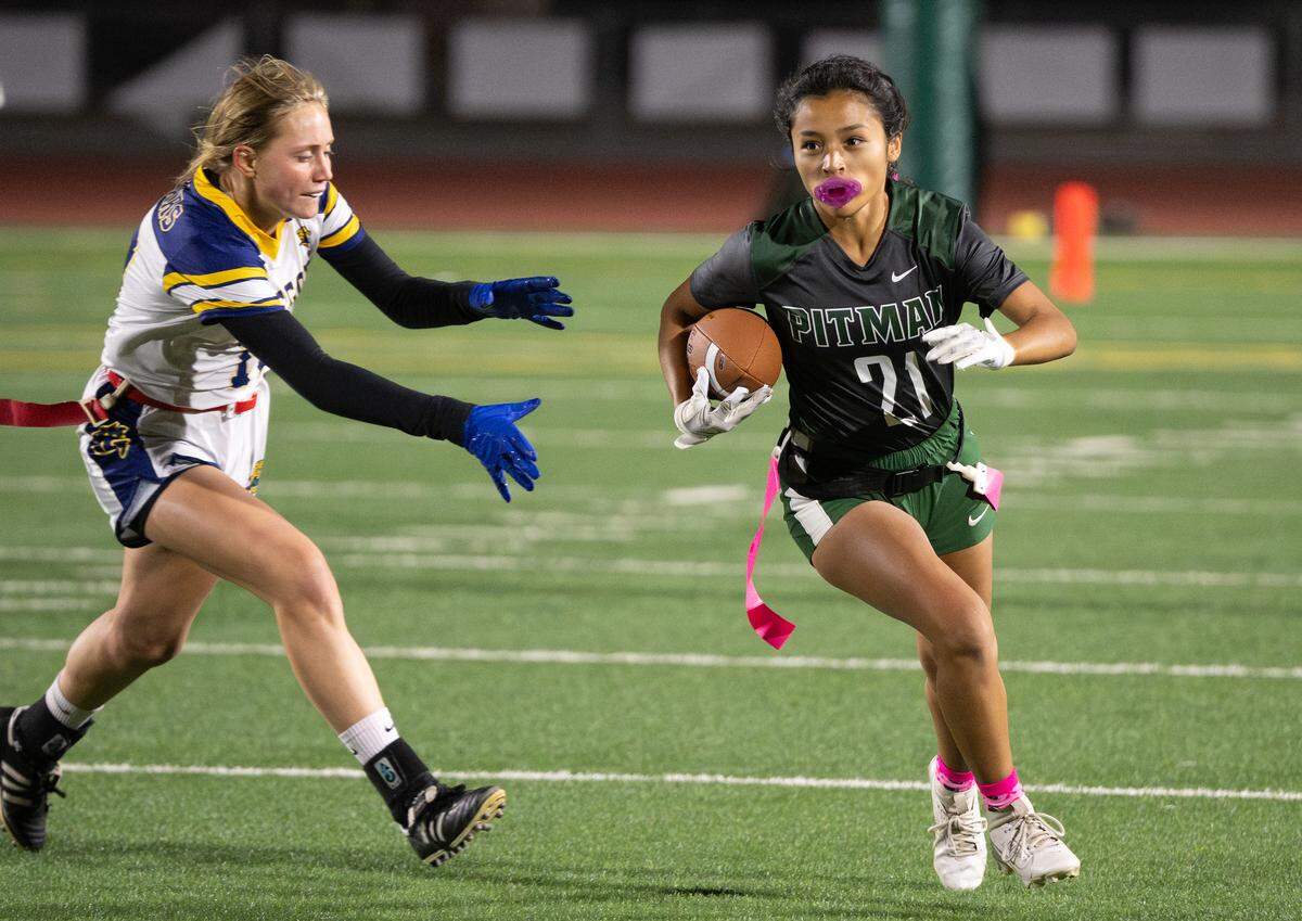 Pitman’s Emily Medina, right, runs the ball as Gregori’s Rachel Warter attempts a tackle during the California Athletic League game at Pitman High School in Turlock on Wednesday, Oct. 22, 2025.  