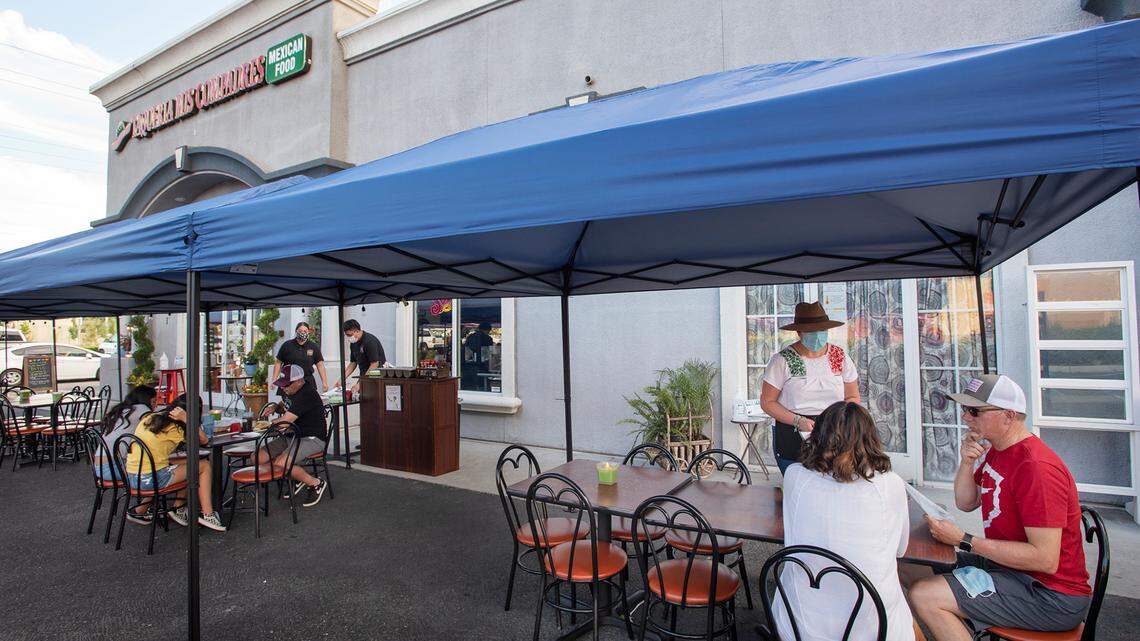 Manager Nayeli Vazquez serves customers Jim and Veronica Norquist at Taqueria Mis Compadres restaurant in Modesto, Calif., on Friday, July 10, 2020.