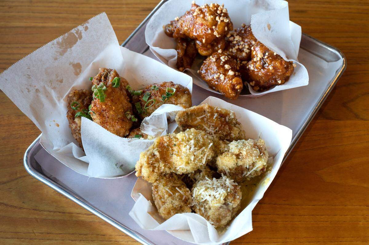 Flavored chicken wings; garlic parmesan, Saigon street (zesty asian sauce), and peanut butter (satay sauce with heat) at Fire Wings restaurant in Turlock, Calif., on Thursday, June 9, 2022.