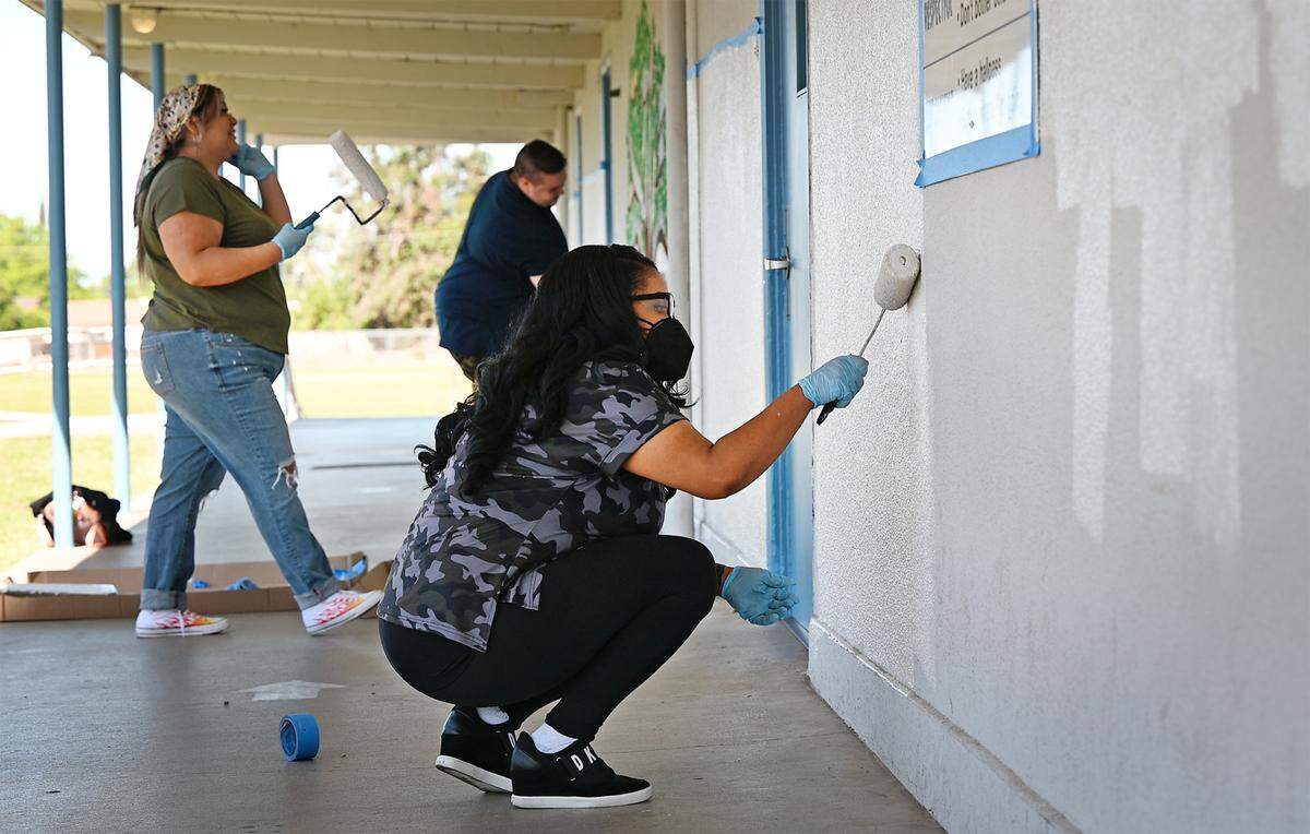 Vanessa Brown, right, Estella Cruz, left, and Andrew Jousset paint at Tuolumne School as part of Love Modesto in Modesto, Calif., on Saturday, April 30, 2022.