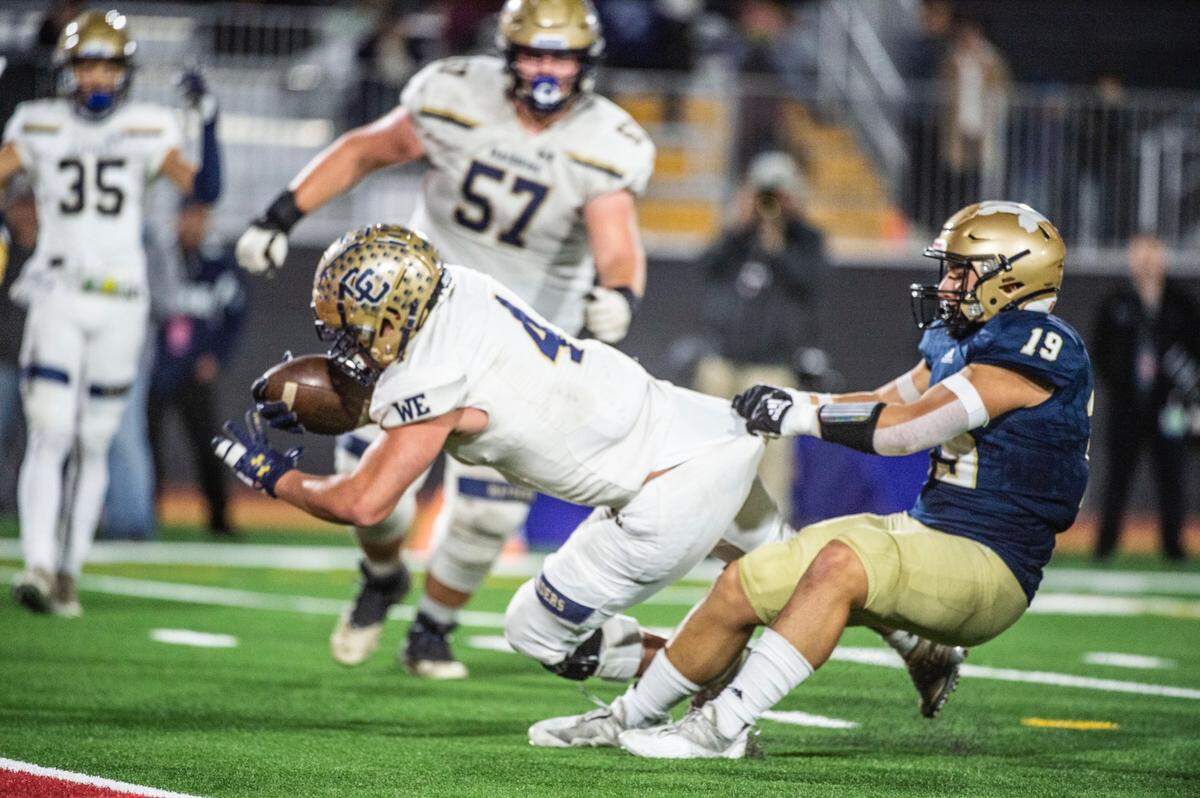 Central Catholic’s Julian Lopez (4) is stopped short of the end zone by Mater Dei Catholic Anthony Lopez (19) during the CIF State Division II-AA Championship Saddleback College in Mission Viejo on Friday, Dec. 10, 2021.