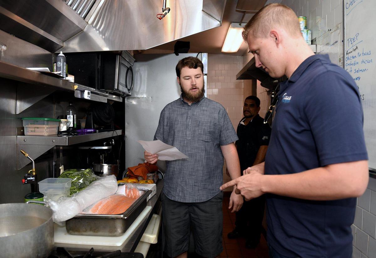 Jason Mensonides goes over a fish delivery with co-owner Jordan Maisetti (center) at Tresettis World Cafe on Thursday August 8, 2019 in downtown Modesto, Calif. The seafood distribution business Ohana Seafood provides fresh seafood to many of Modesto’s fine dining establishments.