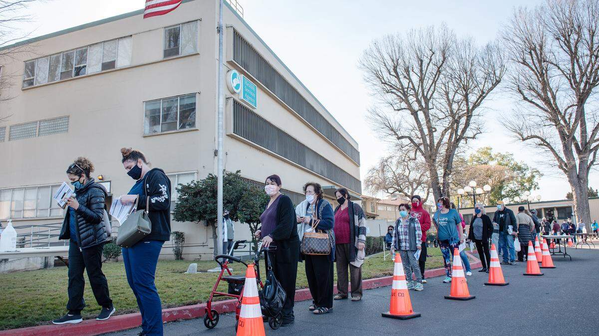 People wait at a COVID-19 vaccination clinic outside the Health Services Agency building on Scenic Drive in Modesto on Thursday, Jan. 14, 2021.
