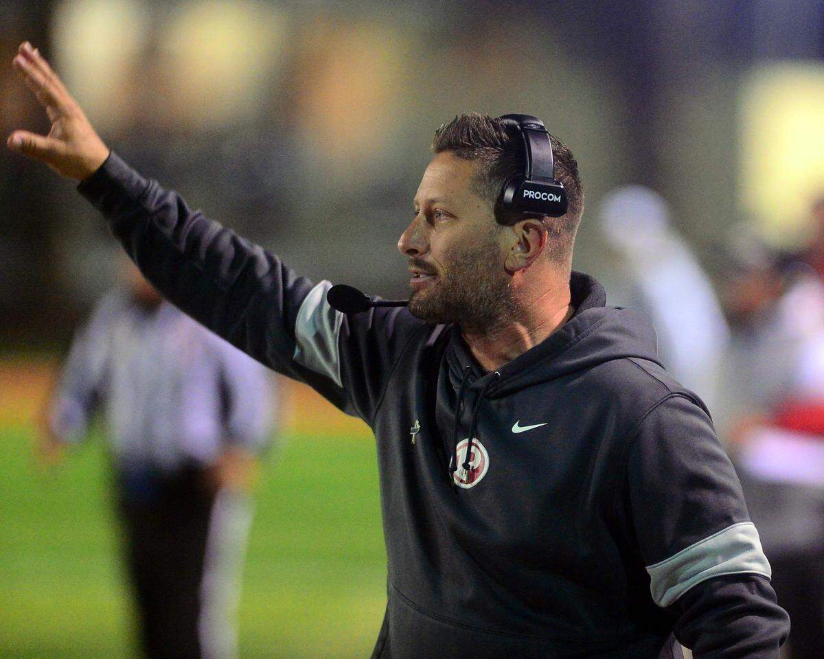 Patterson coach Rob Cozart signals to the defense during a CIF Division III Sac-Joaquin Section football playoff game against Roseville at Patterson High School in Patterson, California, on Nov. 11, 2022. Patterson won 56-34.