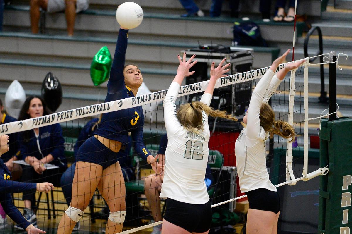 Turlock’s Jazmyn Tubbs (3) spikes the ball while going up against two Pitman blockers, during the senior night, crosstown volleyball matchup of Turlock High at Pitman High, on Monday, Oct., 15 in Turlock, California.