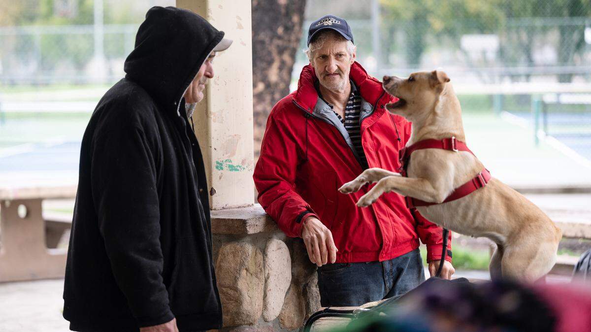 Homeless residents Gary McNeil, right, and Kevin Walker, left, with Walker’s dog Ally at Graceada Park in Modesto on March 29, 2023.