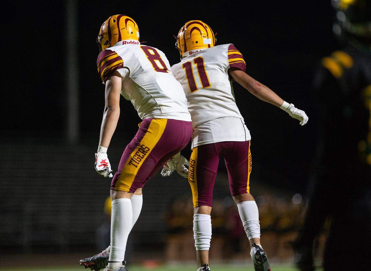 Los Banos players Mark Carreiro (11) and Kayson Welch (8) celebrate a touchdown during a Western Athletic Conference game with Davis at Downey High School in Modesto, Calif., on Friday, September 23, 2022.