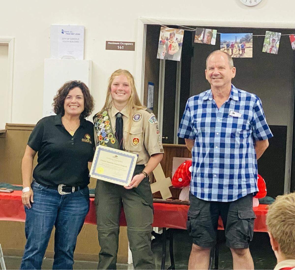Nellie Matthews accepting an award on behalf of Troop 43 from Oakdale Mayor Cherilyn Barios and Mayor Pro Tem Christopher Smith. on Jul. 31, 2024.