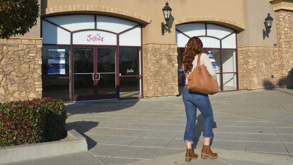 A shopper walks past the former Justice space which has been leased to a new tenant in the Riverbank, Calif. Crossroads shopping center Jan. 19, 2022.