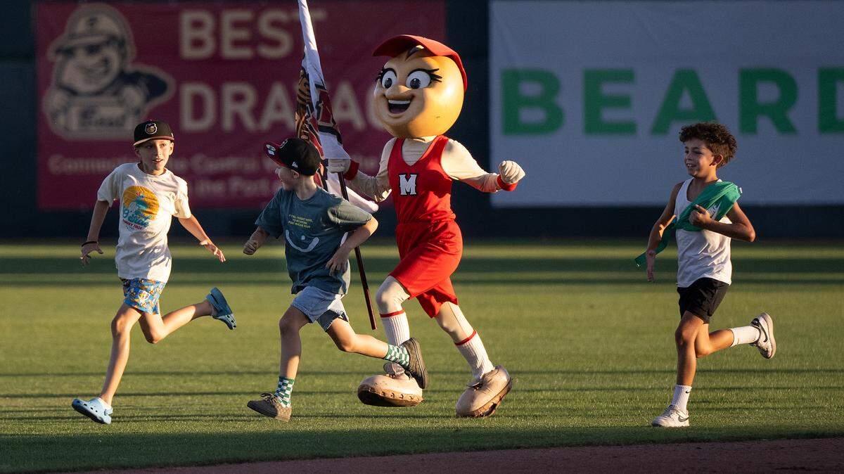 Modesto Nuts mascot Shelly the Pistachio runs the field with kids during an inning change at John Thurman Field in Modesto, Wednesday, June 18, 2025. The Nuts will host the final home series in franchise history at John Thurman Field Aug. 26-31.