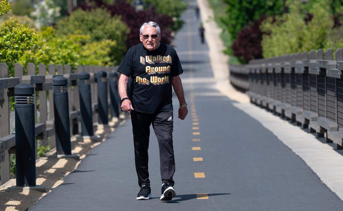 John Scheuber, 84, walks on the Virginia Trail in Modesto, Calif., Wednesday, April 10, 2024. Scheuber completed a goal set 11 years ago of walking the circumference of the earth, or 24,901 miles.