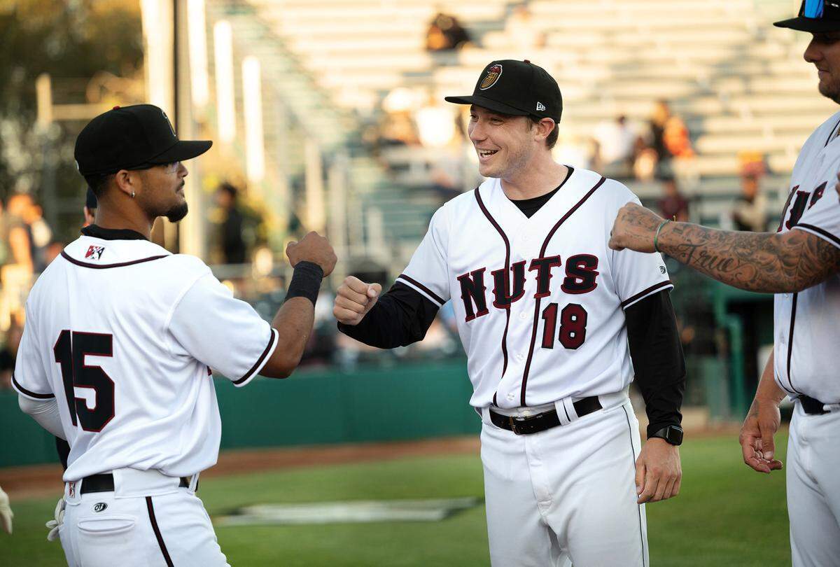 The Modesto Nuts manager Zach Vincej greets Edryn Rodriguez (15) during player introductions before the opening day game their first home game of the season against the San Jose Giants at John Thurman Field in Modesto, Calif., Tuesday, April 11, 2023.