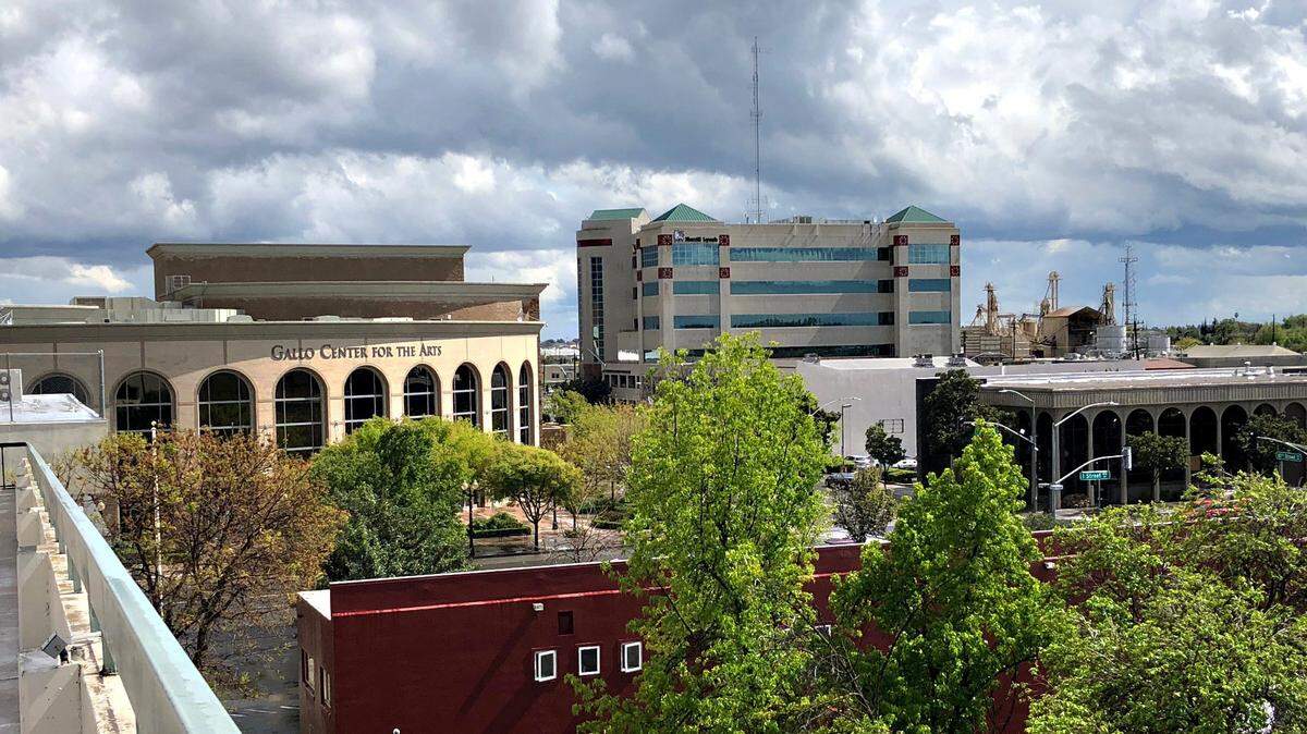 Rain clouds hang over a cityscape in downtown Modesto-(11th street looking south) Monday April 16, 2018 in Modesto, Calif.