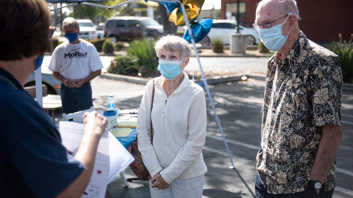 Barbara and Howard Negrens, right, pick up thier goodie bags and t-shirts for the Modesto Rotary Club Senior Stride walk from Peggy O’Donnell, left, at Grocery Outlet parking lot in Modesto, Calif., on Saturday Sept. 19, 2020. It’s the 29th year for the walk and 2020 will be a virtual walk with seniors participating via Zoom and walking individually on their own.