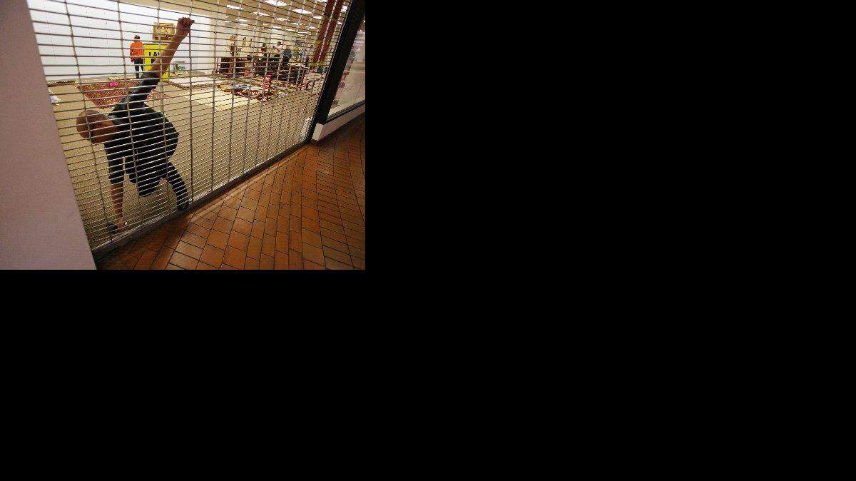 A Gottschalks employee locks one of the gates to the store from the mall entrance at Manchester Center Sunday, June 28, 2009. The store cleared out merchandise with sales of up to 95 percent off before closing the store for good Sunday afternoon.
(CRAIG KOHLRUSS/THE FRESNO BEE)