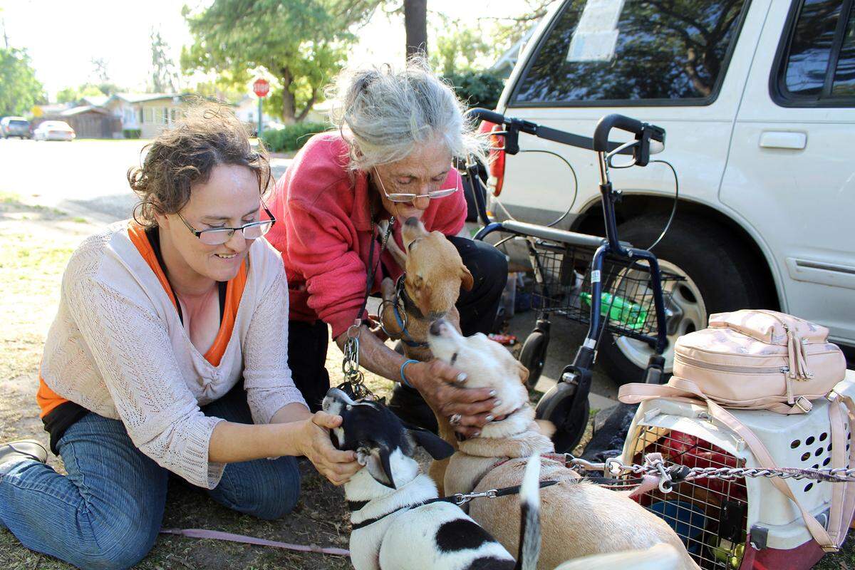 Cathy Young and Cathy Heap play with their dogs at Broadway Park in Turlock, Calif. on Tuesday, April 5, 2022. The mother and daughter are experiencing homelessness.