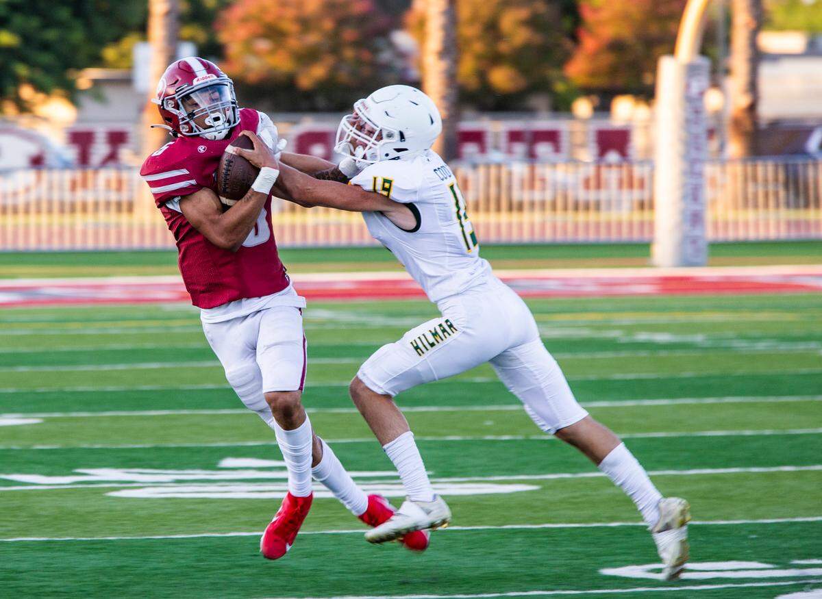 Dj Hardin, 5, of Patterson High grabs a pass as Ryan Couchman, 19, of Hilmar tries to steal the ball.