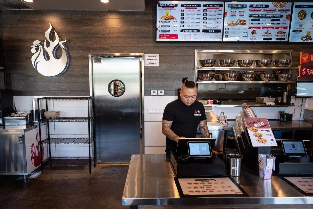 Co-owner Thomas Diep places an order at Fire Wings restaurant in Turlock, Calif., on Thursday, June 9, 2022.