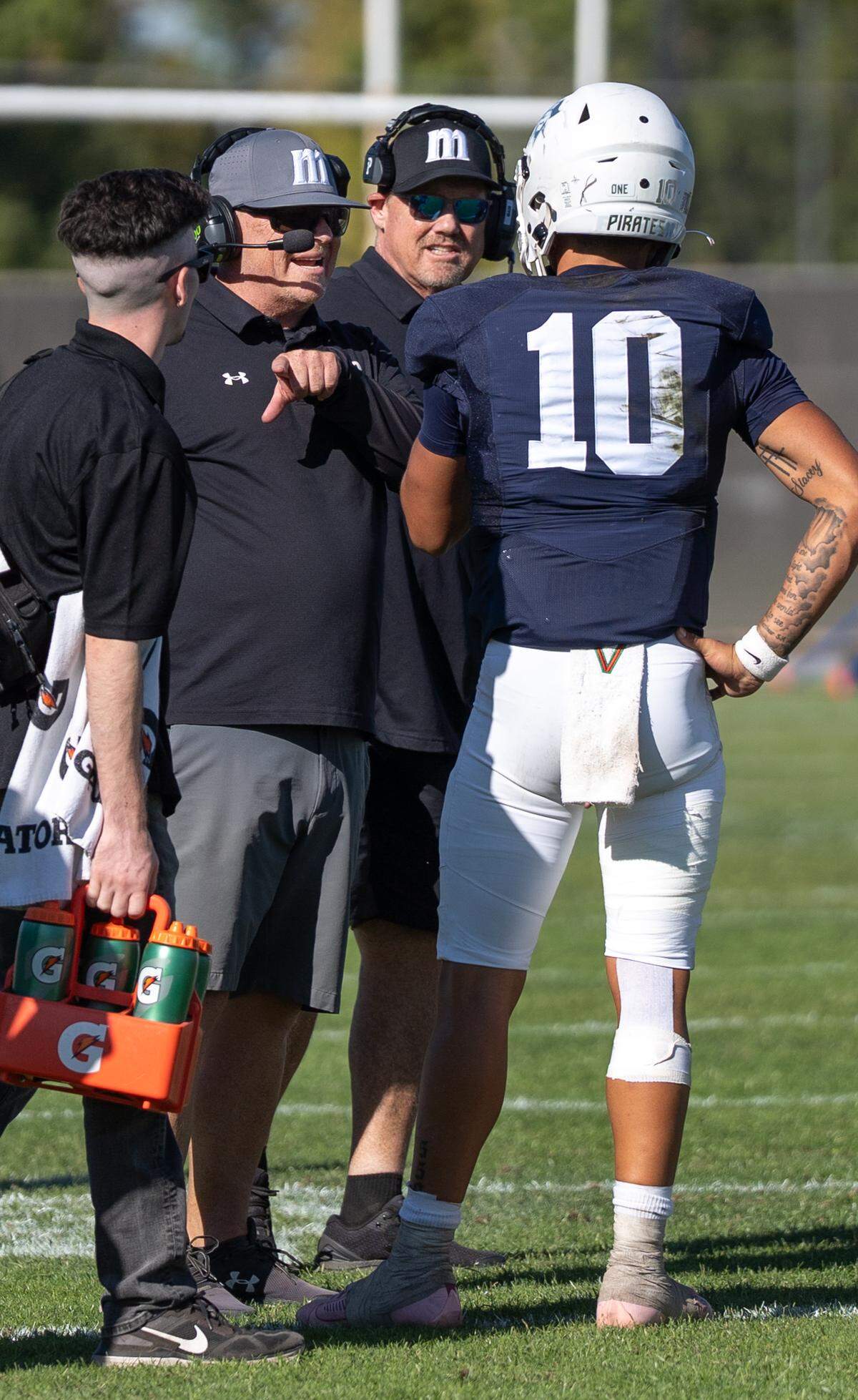 Modesto JC head coach Rusty Stivers talks with quarterback DayDay Tafoya during a timeout during a Valley Conference game against Fresno City College at Modesto Junior College in Modesto, Saturday, Oct. 11, 2025.
