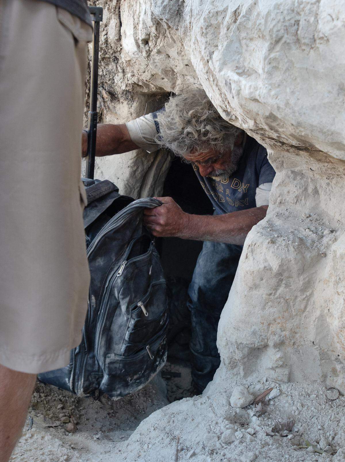 A man illegally camping exits a 10-foot long cave along the south side of the Tuolumne River near Crater Avenue in west Modesto, Calif., Thursday, Oct. 27, 2022.