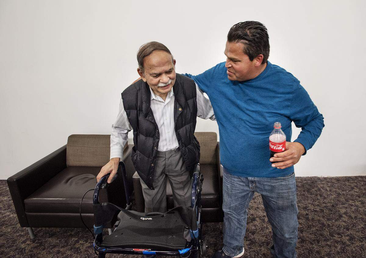Pascual Lemus, right, hugs Anil Sheth after hearing Sheth’s Vintage Faire Mall store, International Imports, will be closing next month. Photographed in Modesto, Calif., on Friday, Feb. 21, 2020.