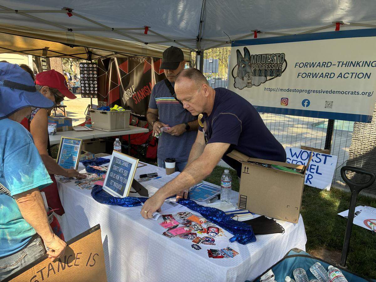 Larry Bolton adjusts giveaways at the Modesto Progressive Democrats booth at the No Kings rally March 28, 2026.