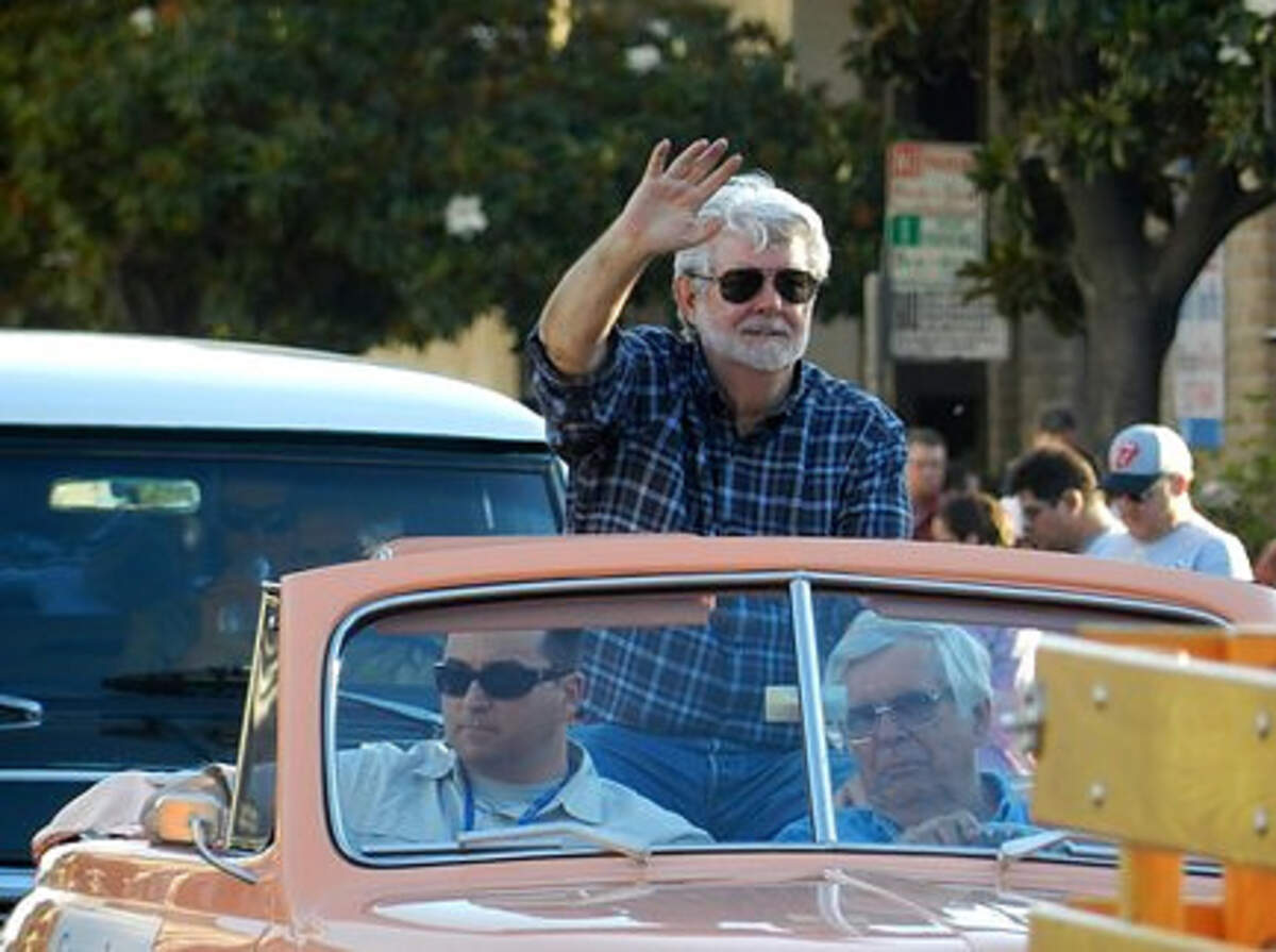 George Lucas waves as grand marshal during the 2013 Modesto American Graffiti Festival parade.