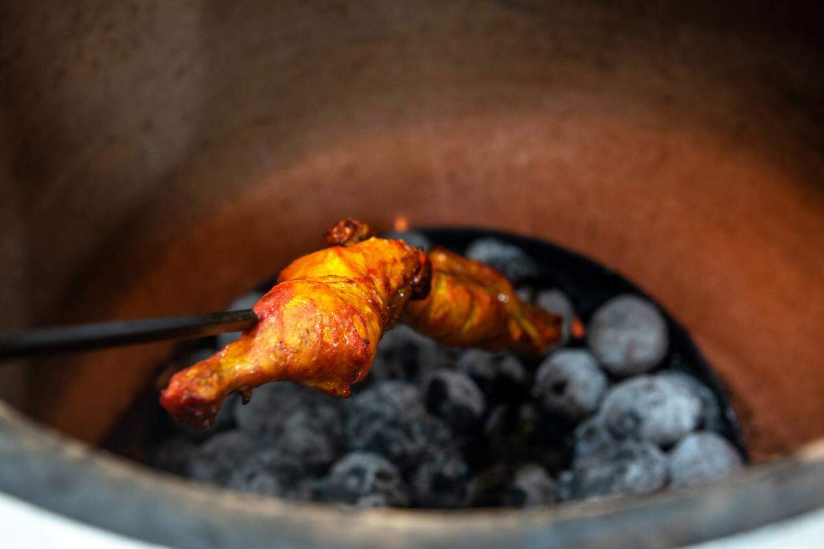 Chicken cooks in the clay oven at Tandoori Flame restaurant in Patterson, Calif., on Friday, April 22, 2022.