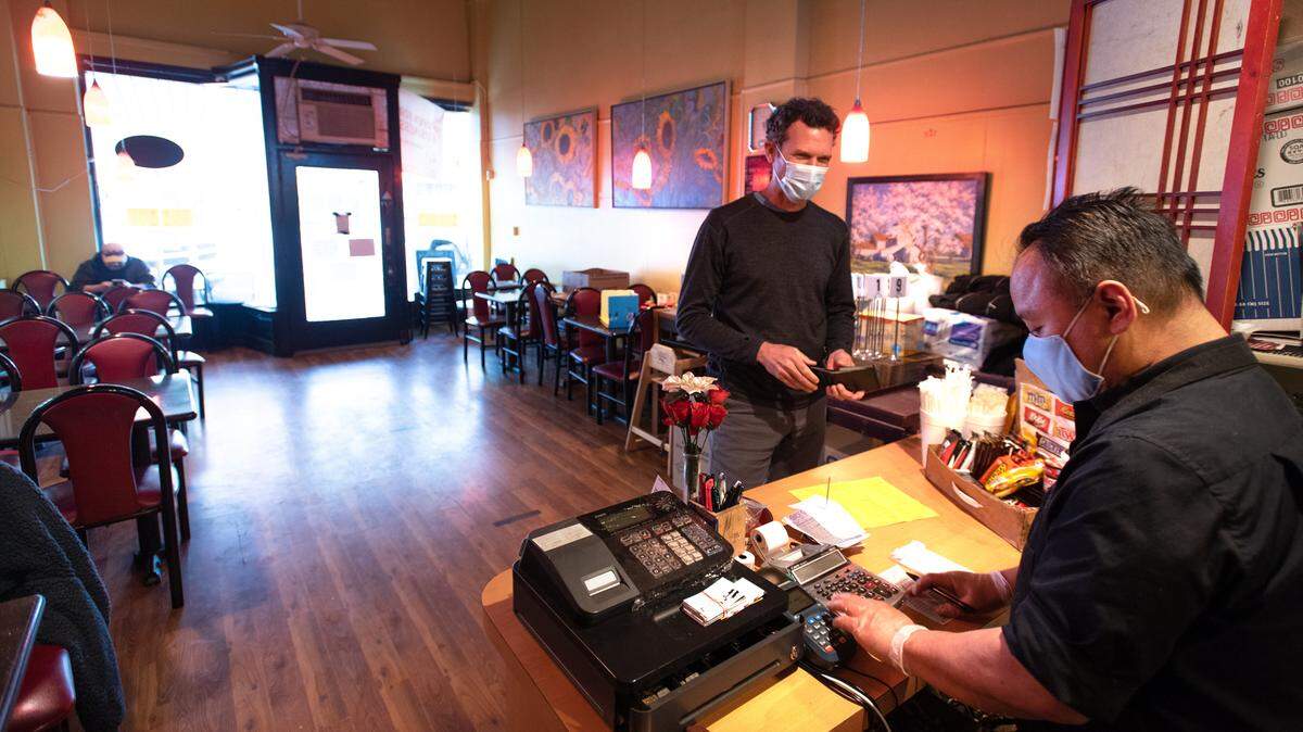 Charlie Dawson, left, orders take-out food from owner George Chen at Tokyo Express restaurant in Modesto, Calif., on Tuesday, March 23, 2021. Stanislaus County was moved to the red tier of California’s coronavirus reopening plan which includes indoor dining at 25 percent capacity.