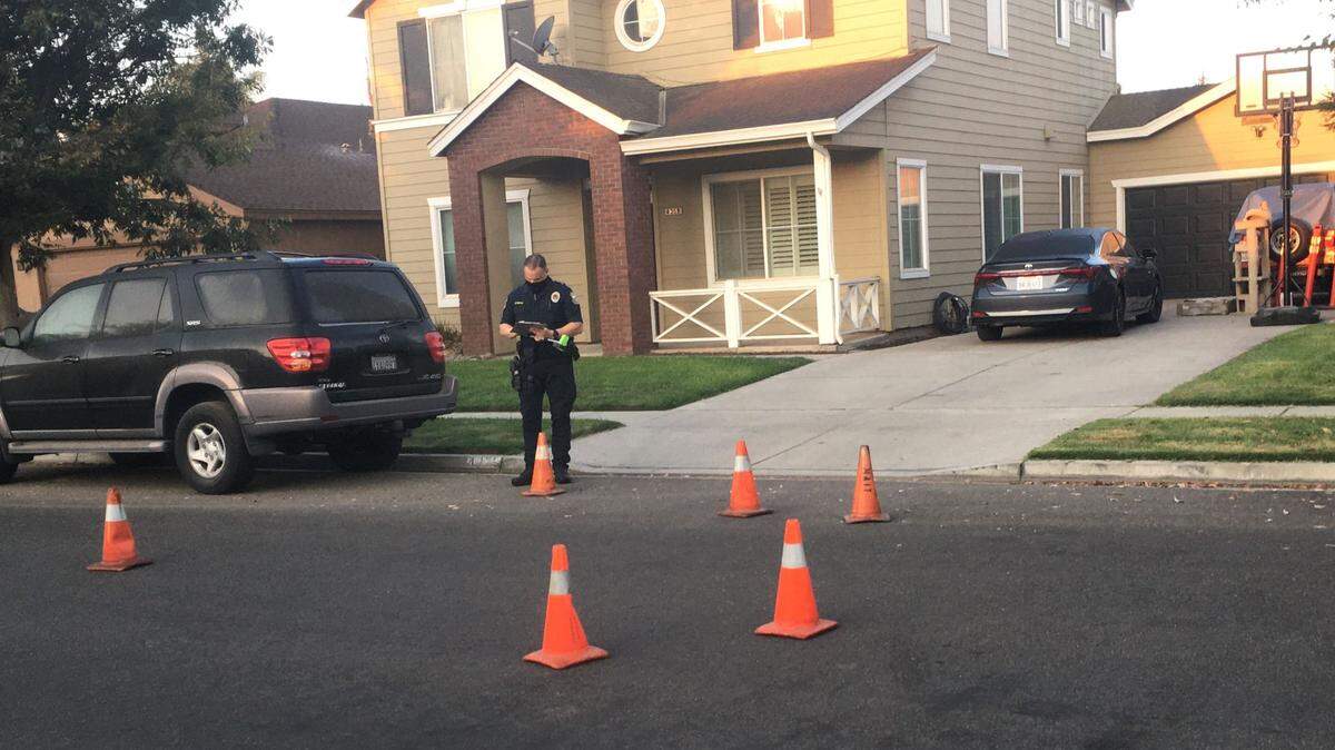 A Turlock police officer investigates the scene on Ferreira Ranch Drive where shots struck a residence on the 4200 block on Tuesday morning, Oct. 6, 2020.
