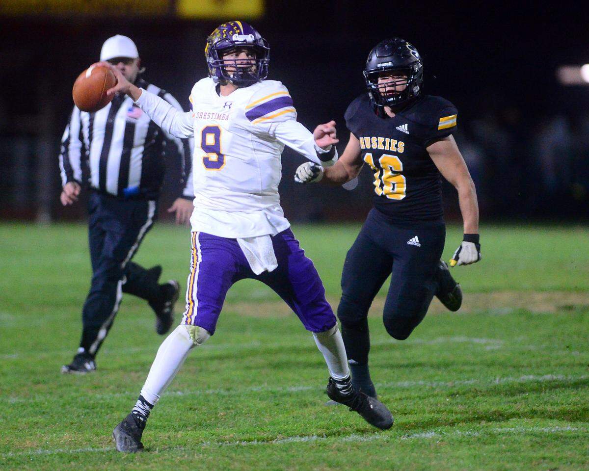 Orestimba quarterback Alex Millan reaches back to throw on the run during a CIF Division VI Sac-Joaquin Section playoff game against Hughson at Hughson High School in Hughson, California, on Nov. 18, 2022. Hughson won 21-17.