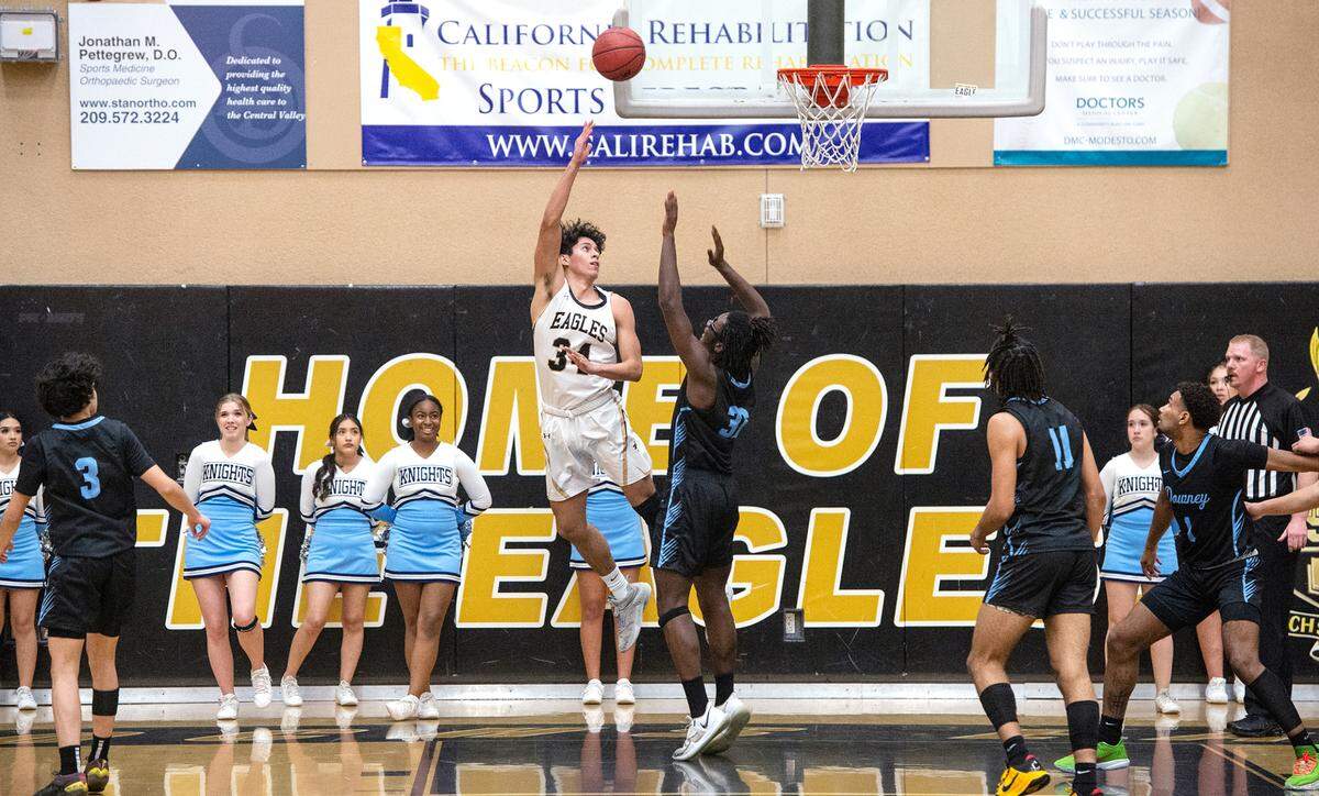Enochs’ Emiliano Arreola attempts a hook shot over Downey’s Calaun Lee during the Central California Athletic League at Enochs High School in Modesto, Calif., Friday, Jan. 27, 2023. Downey won the game 47-40.