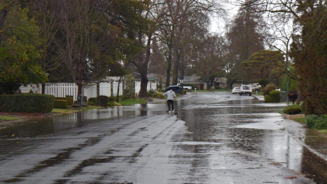 To avoid flooding on Cheshire Lane and its sidewalks, Manny Olmos carefully makes his way down the middle of the north Modesto street on Sunday morning, Feb. 4, 2024.