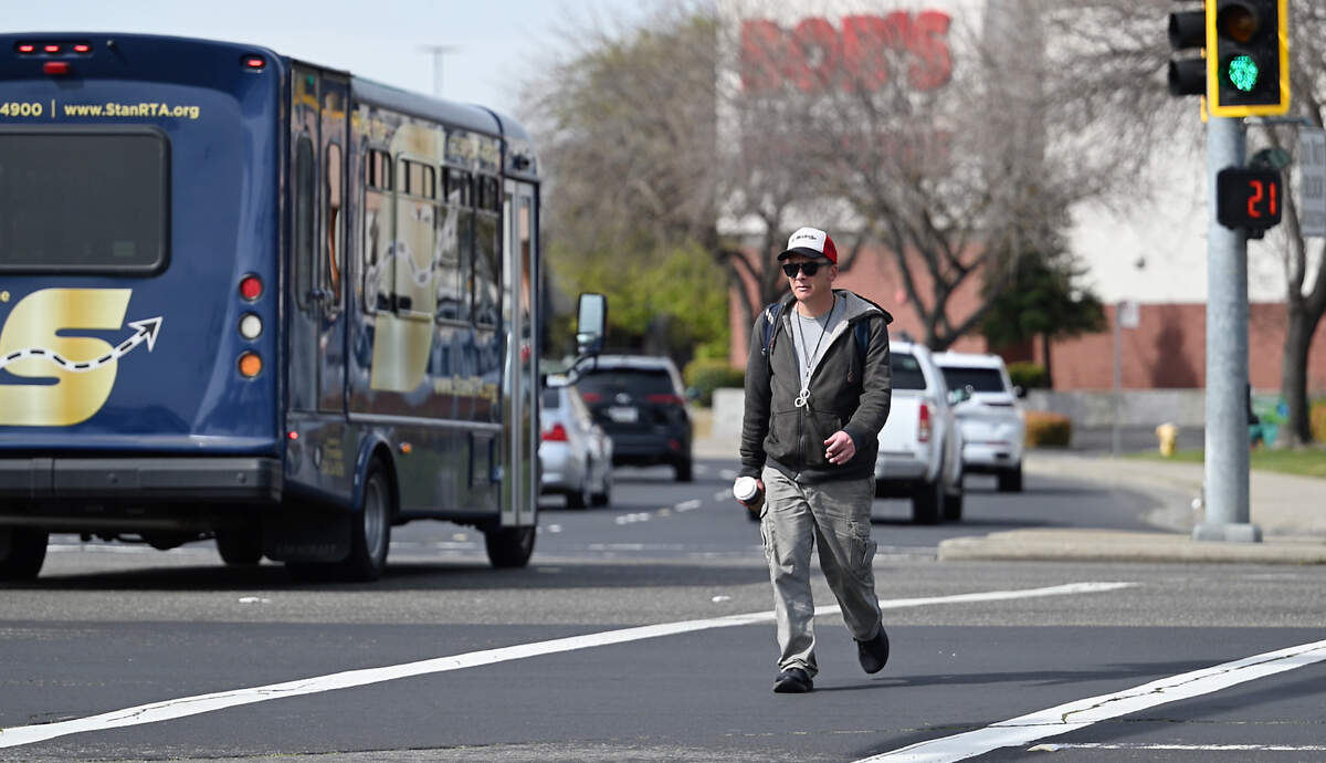 A pedestrian crosses Standiford Avenue on Sisk Road in Modesto, Calif., Saturday, March 9, 2024.