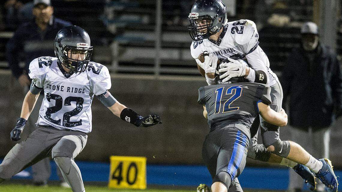 Stone Ridge Christian senior Cole Houweling (26) is hit by Ripon Christian senior Dillon Zuidervaart (12) during a Sac-Joaquin Section Division VII playoff game at Ripon Christian High School in Ripon, Calif., on Friday, Nov. 17, 2017. Ripon Christian beat Stone Ridge Christian 39-3.