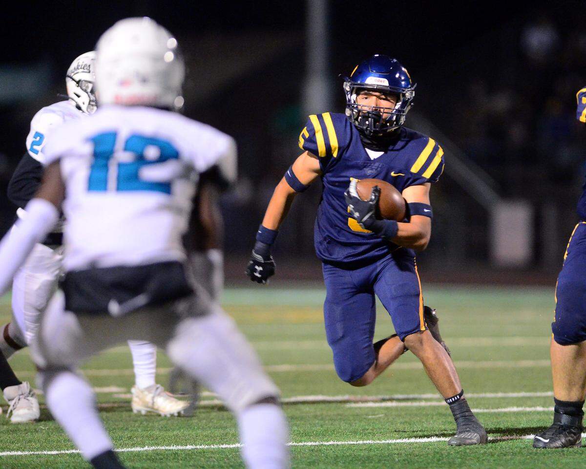 Turlock running back Jeremiah Bertalotto (5) eyes multiple defenders during a CIF Sac-Joaquin Section Football Division I playoffs game between Turlock High School and Sheldon High School at Turlock High School in Turlock, California on Nov. 3, 2023.