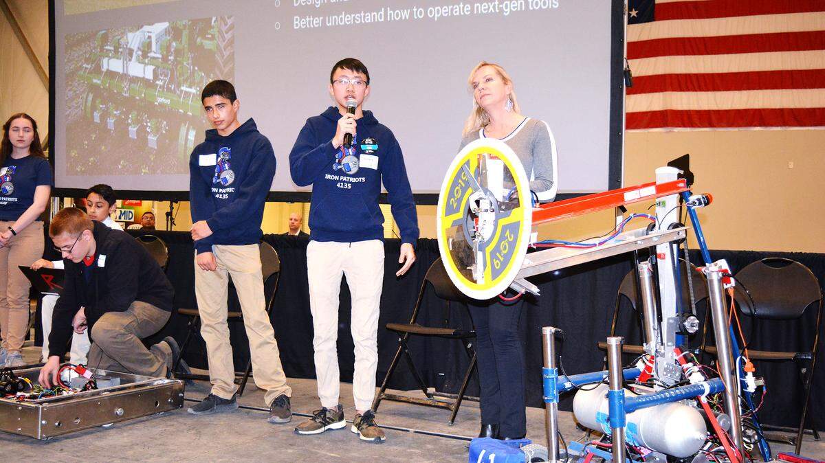 Beyer High School robotics team member David Wong, center, speaks at the Agtech Summit in Modesto, California, on Thursday, Feb. 6, 2020. He is flanked by teammate Joe Leon and teacher Heidi Pagani.